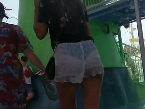 Shy girl tries to hide her ass and thong in wet shorts