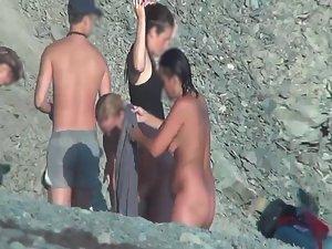 Nudists removing clothes on a beach Picture 8