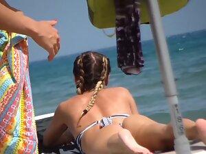 Voyeur inspects fit girl while she sunbathes on beach Picture 2