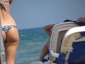 Voyeur inspects fit girl while she sunbathes on beach Picture 7